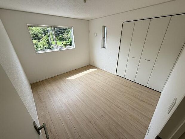 大きな窓から自然光が差し込む寝室です。収納スペースも備わっておりすっきりとした印象です。明るい床材が室内を開放的に演出しています。クローゼットの扉もシンプルで使いやすいデザインです。