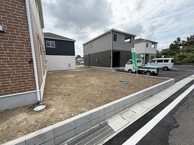 日当たりが良く開放感のある庭スペースです。整地済みで手入れがしやすくシンプルな形状が特徴的です。住宅の外観とも調和する落ち着いた雰囲気です。車からのアクセスも便利です。