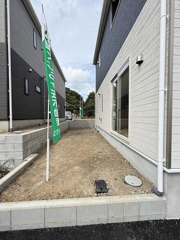 建物横に設けられた庭スペースが広がっています。建物と道路の間にしっかりとしたブロック塀が設置されています。シンプルな外観に合うすっきりとした庭です。建物に面した大きな窓から庭を眺めることができます。