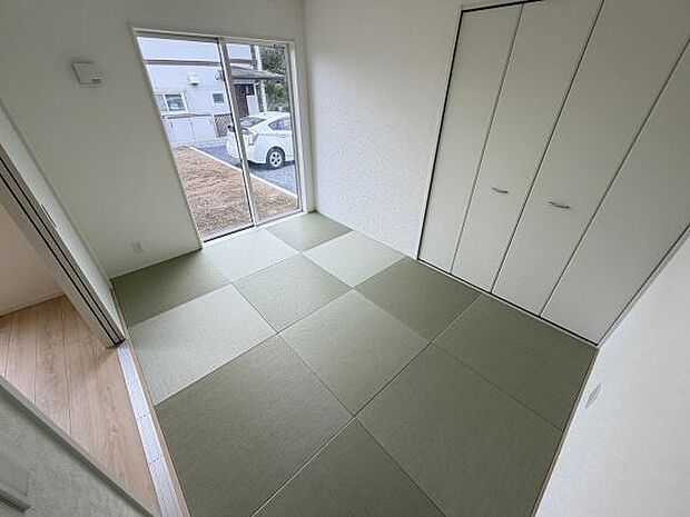 和室には大きな窓があり自然光がしっかり入ります。畳の色合いが落ち着いた印象を与えます。奥には収納スペースが備え付けられており整理整頓に便利です。モダンな雰囲気の和室となっています。
