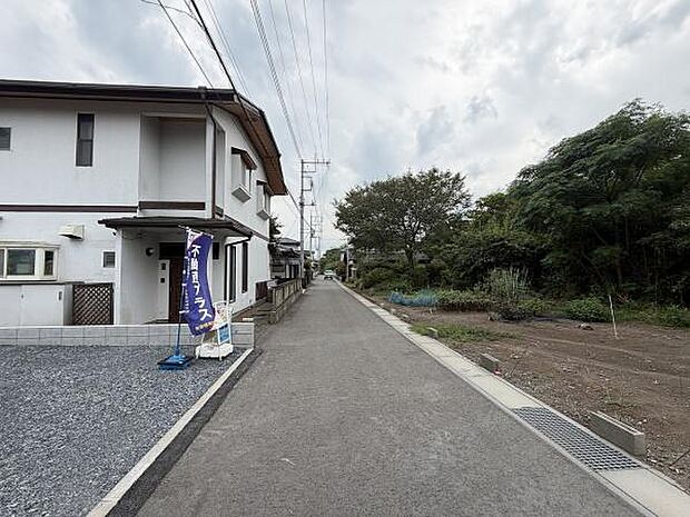 前面道路は舗装されており車の出入りもスムーズに行えます。周辺は緑が広がり開放感のあるロケーションです。歩道も整備されていて安心感があります。道路幅も確保されているため見通しも良好です。