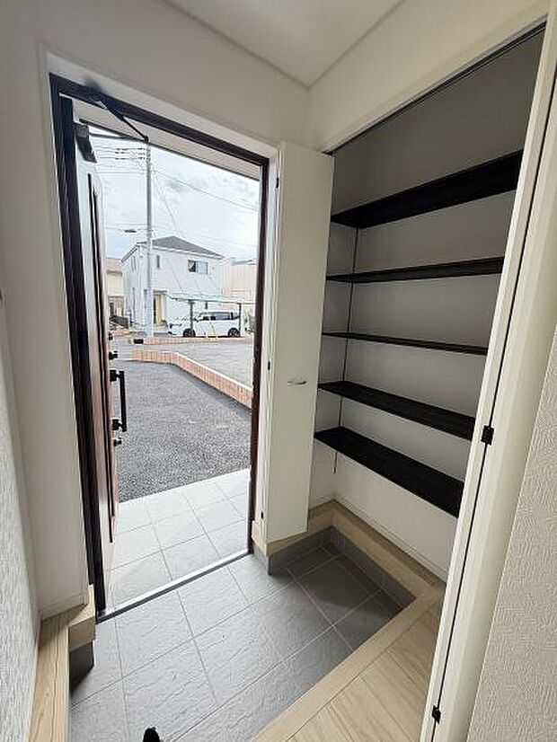 玄関に使いやすい収納棚が備わっており収納力に優れた設計です。明るい採光の玄関スペースは清潔感があります。土間部分が広めに確保されており使い勝手も良好です。開放感のある玄関が印象的です。