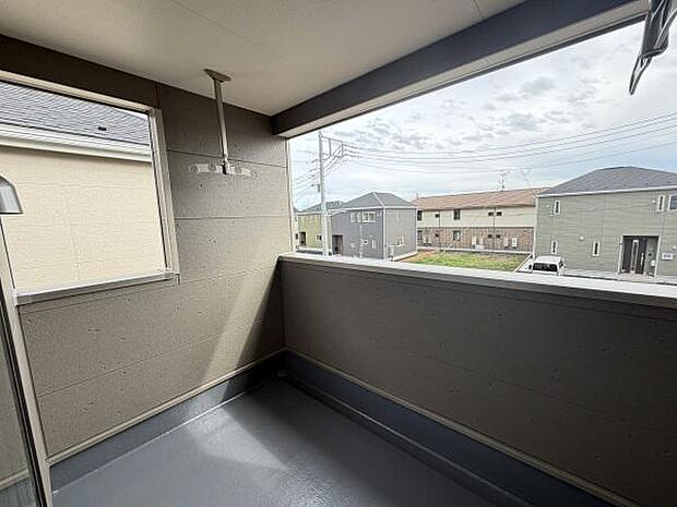 広々としたバルコニーは開放感ある空間が広がっています。屋根付きのため天候を気にせず活用できます。洗濯物を干せる金具も設置されており日常使いに便利です。窓から光が差し込み明るさも感じられる仕様です。