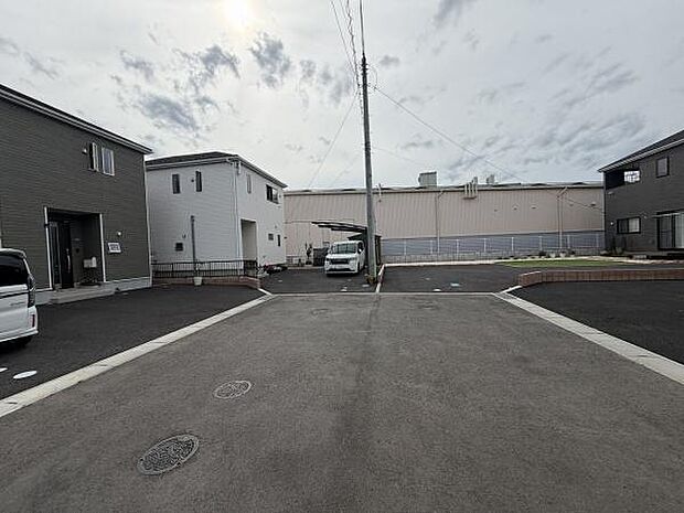 ゆとりある前面道路が印象的な現地写真です。車の出し入れもスムーズに行えます。周囲は整然とした街並みで清潔感があります。幅広い道路が安全に配慮されています。