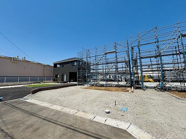 新築工事が進行中の様子が確認できます。敷地が広々としており様々な使い道が考えられます。すっきりとした道路に面し現地の様子がわかりやすい写真です。青空が広がり開放的な雰囲気が印象的です。