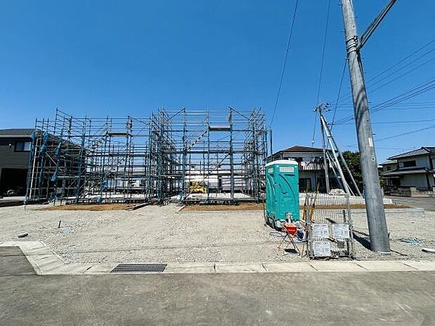 広々とした敷地に整然と組まれた足場が印象的です。周辺には道路や住宅があり利便性を感じさせます。建物の建設過程を確認できる現場写真です。晴天の空の下整った現場環境が広がっています。