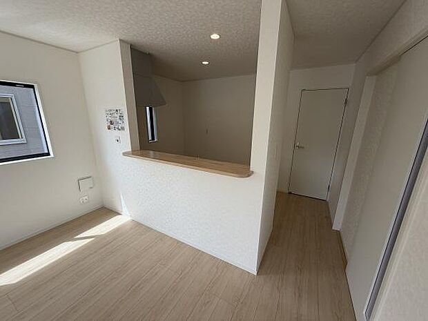 ナチュラルなフローリングと白を基調としたデザインが明るく開放的なキッチンを演出しています。カウンター付きで空間にゆとりがあります。窓からの自然光が心地よさをプラスします。