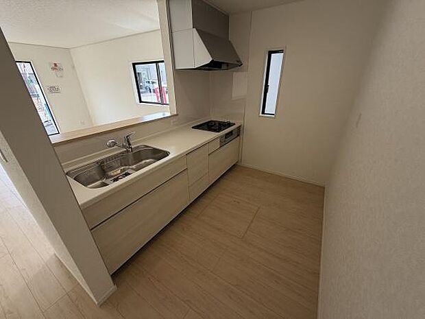 窓から自然光が入り込む明るいキッチンです。シンプルなデザインでお手入れがしやすい仕様となっています。広々とした調理スペースも確保されています。収納も豊富で使い勝手の良さがポイントです。