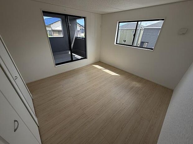 二面採光で日当たりが期待できる寝室です。シンプルな内装でレイアウトの自由度があります。バルコニーに面した窓からも光が入ります。収納スペースも備わっています。清潔感のある空間です。