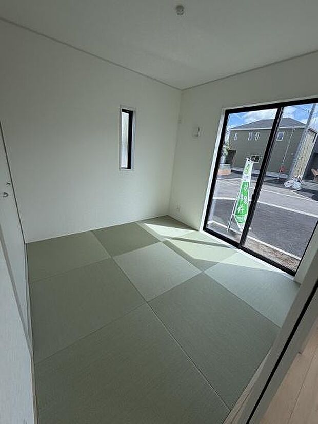 大きな窓から自然光がたっぷり入る和室です。シンプルで整った空間が印象的です。畳が清潔感を演出し落ち着いた雰囲気を感じさせます。独立した明るい空間でゆったり過ごせます。