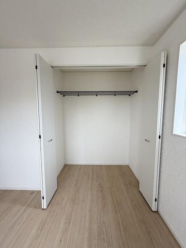 明るい色調の収納スペースで室内がすっきりとした印象です。両開きドアで使いやすさに配慮されています。ハンガーパイプ付きで便利です。収納内のスペースも広々としています。シンプルなデザインが特徴です。