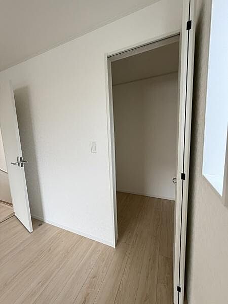 シンプルな内装が特徴の収納スペースです。出入りしやすい扉が設置されています。お部屋と同じフローリング仕上げで統一感があります。無駄のない空間設計がされています。明るい印象の収納です。
