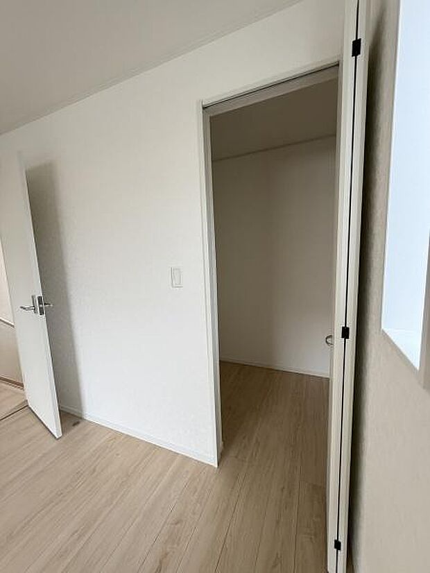 シンプルな内装が特徴の収納スペースです。出入りしやすい扉が設置されています。お部屋と同じフローリング仕上げで統一感があります。無駄のない空間設計がされています。明るい印象の収納です。