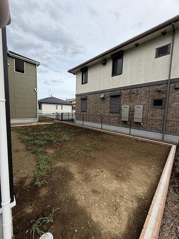 囲いのある庭スペースは建物と調和したシンプルな造りです。日当たりもよく土のエリアが広がっています。お手入れやアレンジにも対応しやすい形状です。植栽や活用方法が自由に考えられます。
