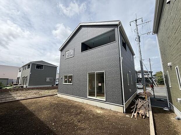 スタイリッシュな外観が印象的な戸建て住宅です。シックなダークカラーが落ち着いた雰囲気を演出しています。大きな窓が複数配置され室内にも明るさを取り入れやすい設計です。敷地も広く開放感があります。