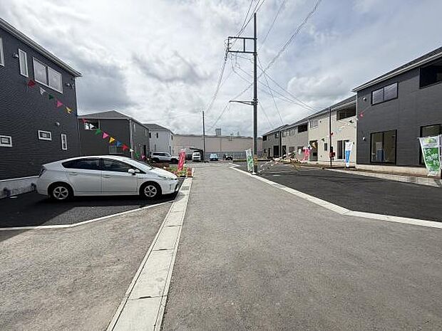 前面道路は幅広く車の出入りもスムーズにできます。周囲の新しい住宅と調和した整然とした現地写真です。道路面も綺麗に舗装されており生活のしやすさが伝わります。駐車スペースも確保されています。