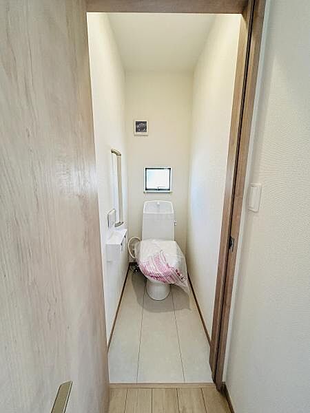 シンプルなデザインのトイレで清潔感が感じられます。窓があり自然光が差し込む明るい空間です。扉や床材にも統一感があり落ち着いた印象です。使い勝手の良い手洗いスペースも設けられています。