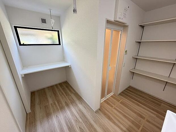 明るい窓付きの洗面スペースがあり空間がすっきりしています。壁付のカウンターが便利に使えます。棚が複数設置されており収納分けに便利です。床は木目調で落ち着いた雰囲気です。