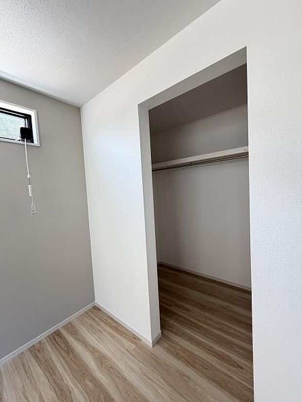 クローゼットが広々としており衣類や荷物の収納がしやすい空間です。シンプルなデザインで整理整頓がしやすく室内がすっきりと保てます。明るい木目調の床が空間を爽やかな印象にしています。