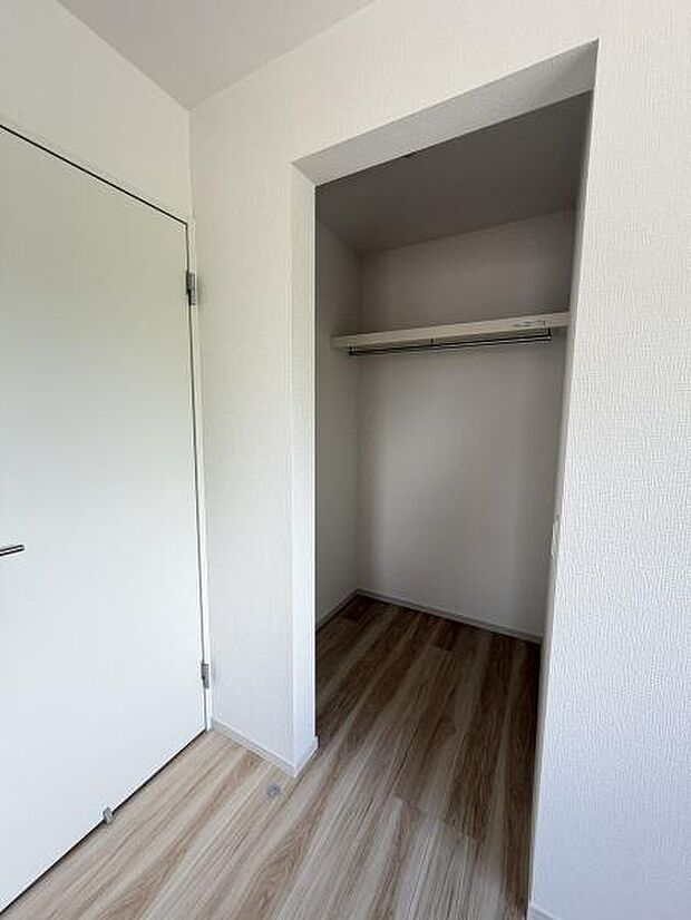 クローゼットにはパイプハンガー付きで洋服などをきれいに並べて収納できます。床や壁紙も落ち着いた色味で統一されています。開口部が広く荷物の出し入れがしやすい構造です。