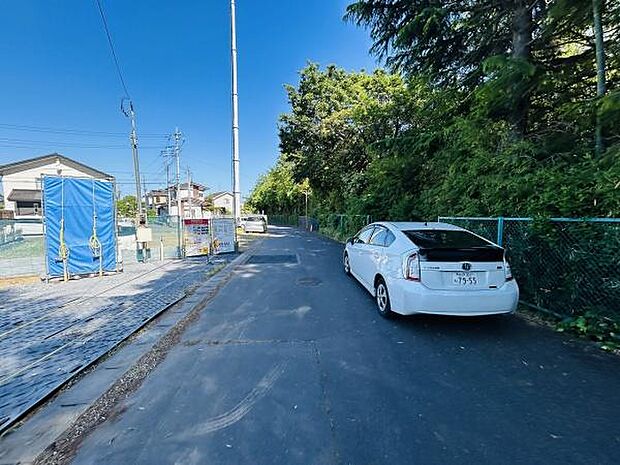 前面道路は幅員が広く車の通行もスムーズに行えます。周囲には自然も多く落ち着いた雰囲気が感じられます。敷地前には駐車スペースも確保されており車の出し入れも安心です。