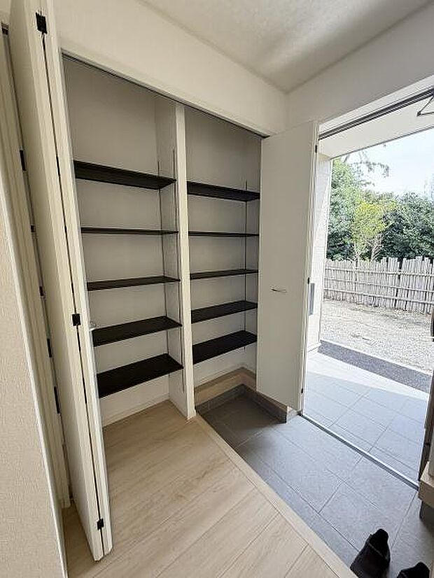 玄関には収納力のある可動棚が備え付けられており使い勝手の良い空間です。明るい光が差し込む設計で室内が広々と感じられます。土間スペースも確保されており靴の脱ぎ履きがしやすいです。