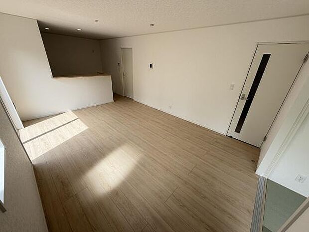 明るい光が差し込むリビングです。シンプルな内装が空間を広く見せてくれます。フローリングの色味が落ち着いた印象を与えています。カウンター越しの視界も開放的です。使いやすさを感じる配置です。