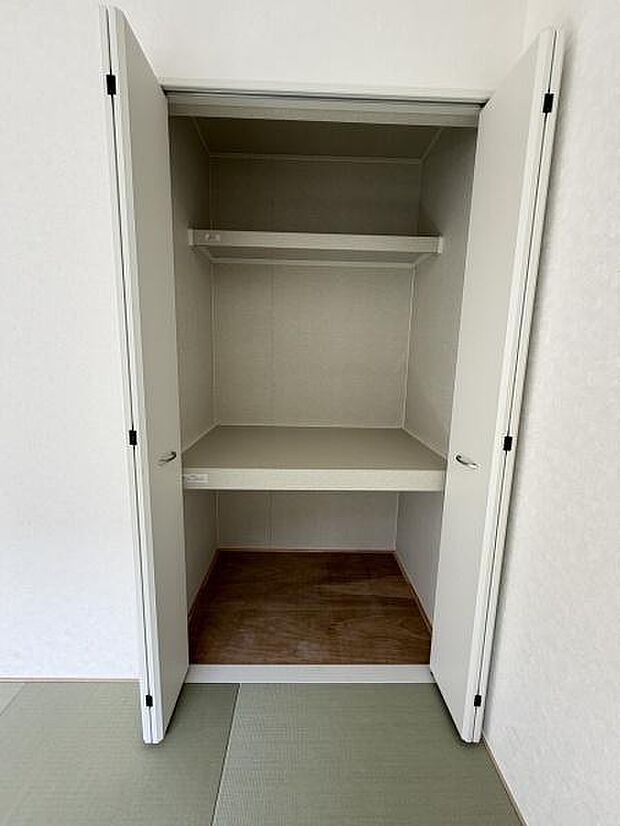 シンプルなデザインの収納スペースです。内部には仕切り棚があり整理整頓に便利です。扉を閉めるとすっきりとした印象になります。畳のお部屋に調和するホワイト色の扉です。開口部が広く使いやすい収納です。