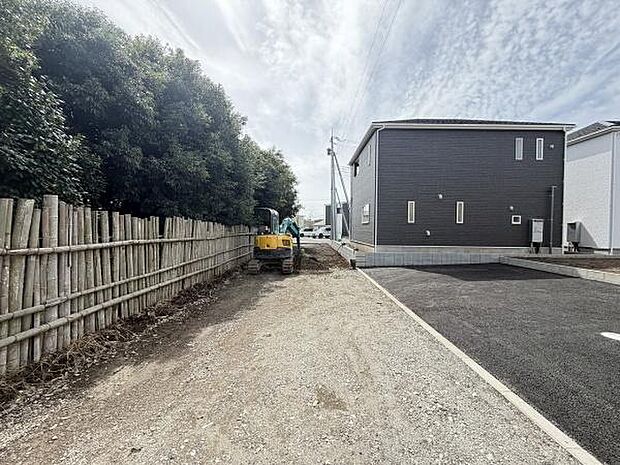 前面道路は幅が広く見通しの良い環境です。道路沿いには竹垣が設けられており目隠し効果も期待できます。新築住宅と舗装済みのアプローチが印象的です。現地周辺はゆったりとした雰囲気です。