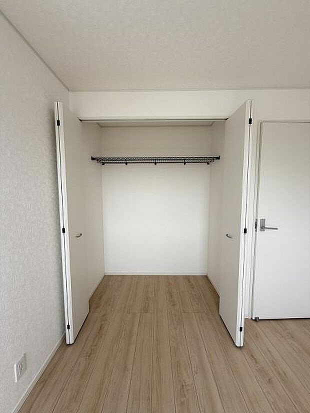 シンプルなデザインの収納スペースです。扉が大きく開く仕様で物の出し入れがしやすいです。ハンガーパイプ付きで衣類の整理整頓がしやすいです。お部屋と統一感のある仕上がりとなっています。