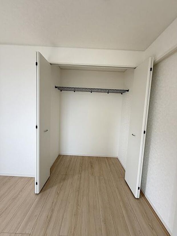 シンプルなデザインの収納スペースです。扉はスムーズに開閉できお部屋の雰囲気と調和しています。ハンガーパイプ付きで衣類の整理に便利です。フローリングとも相性がよい仕様です。