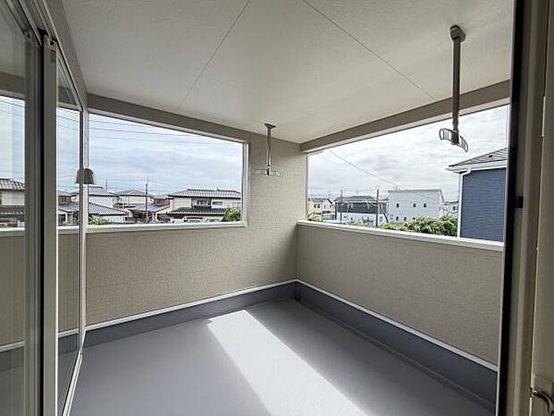 開放的な空間で採光も良好なバルコニーです。屋根付きで天候に左右されにくく多目的に活用できます。周囲の景色もしっかり眺められる設計です。物干し金具が設置されており便利に使えます。