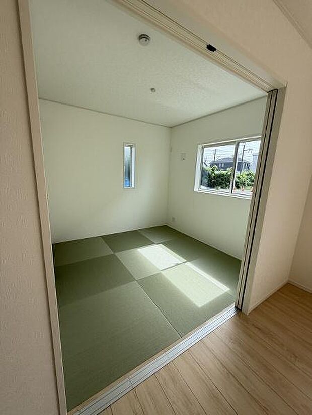 明るい光が差し込む和室です。落ち着いた雰囲気が感じられるシンプルな空間となっています。引き戸で開放感を出しやすく畳の質感も楽しめます。角部屋のため採光も確保されています。