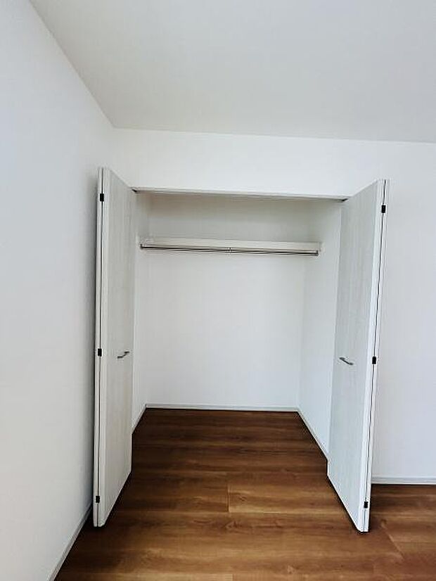 シンプルなデザインの収納スペースが備え付けられています。両開きの扉で開口部が広く使いやすいです。高さのあるハンガーパイプが設置されており衣類の整頓にも便利です。内装と床材のコントラストも魅力的です。