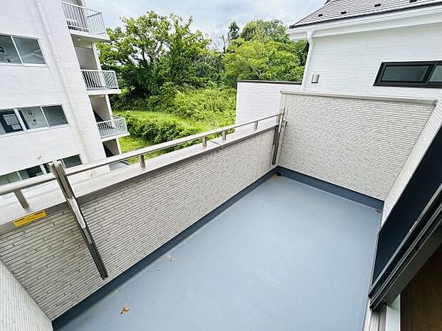 バルコニーはゆったりとしたスペースを確保しており開放感があります。周囲には緑が広がり視界も良好です。壁や手すりもシンプルなデザインで外観に調和しています。メンテナンスのしやすい床面もポイントです。