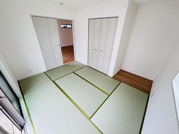 明るい日差しが入る和室です。シンプルな内装で落ち着いた雰囲気が漂います。収納スペースが備わっているためすっきりと片付けやすい設計です。引き戸で隣室との一体感も感じられます。