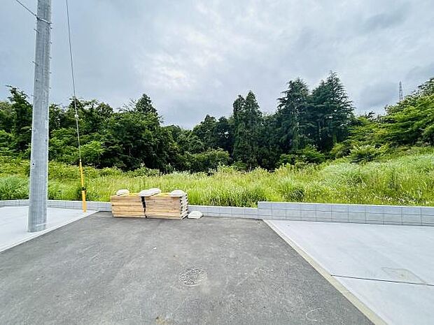 前面道路を含む現地写真です。視界がひらけており開放感があります。周囲には豊かな緑が広がっています。道路は整備されていてすぐにご利用いただけます。落ち着いた雰囲気の立地です。