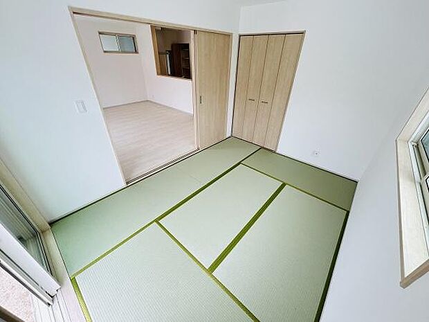 明るい光が差し込む和室です。落ち着いた雰囲気の中で幅広く活用できます。押入れ収納付きで整理整頓も便利です。リビングと繋がるため空間に広がりを感じられます。清潔感のある内装です。