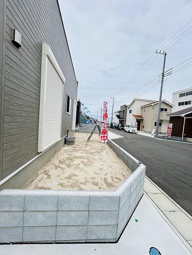 シンプルな外構デザインで家の外観と調和した庭が広がっています。道路に面しているため開放感が感じられる空間となっています。手入れしやすい砂利敷きが特徴です。