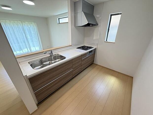 明るい空間に配置されたキッチンは窓から自然光が差し込み開放感があります。収納力のあるキャビネットで整理整頓もしやすいです。シンプルな配色が清潔感を演出しています。