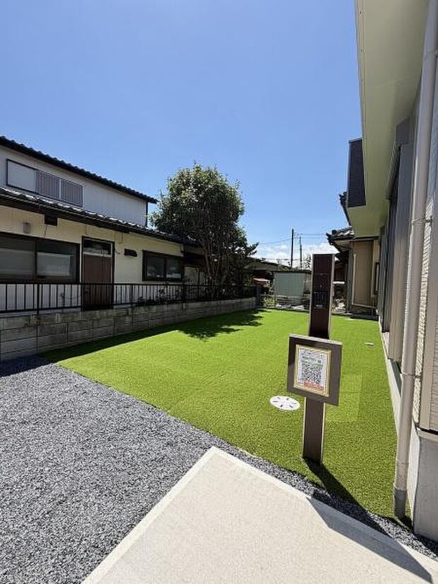 人工芝が敷かれた庭は手入れがしやすくすっきりとした印象です。隣家との間に塀がありプライベート空間が確保されています。開放感のある空が広がり日当たりも十分です。ゆとりのあるスペースが確保されています。