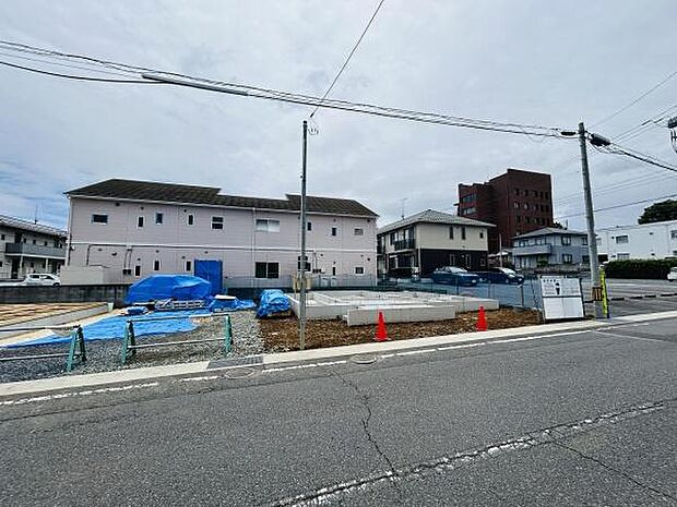 現在建築中の敷地が広がっています。周囲には住宅や建物が並び落ち着いた道路に面しています。生活利便施設も近隣に点在しています。前面道路は舗装されており車両の出入りがしやすい配置です。