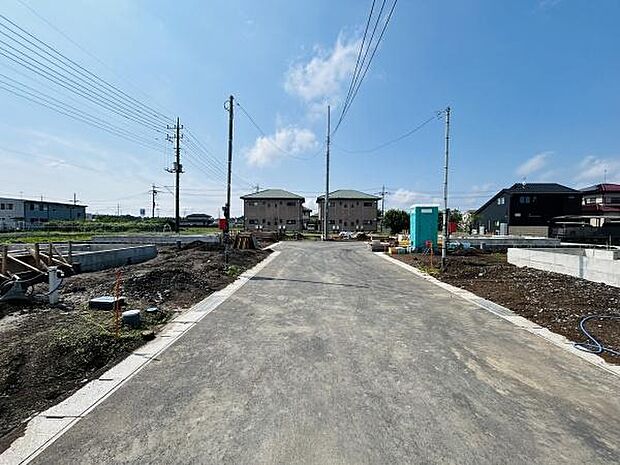 現地の前面道路は広々としており車の出入りがしやすい環境です。周辺は建築中の区画が多くこれから新しい街並みが形成されていきます。電柱や配線も整然として開放感を感じられる現地写真です。