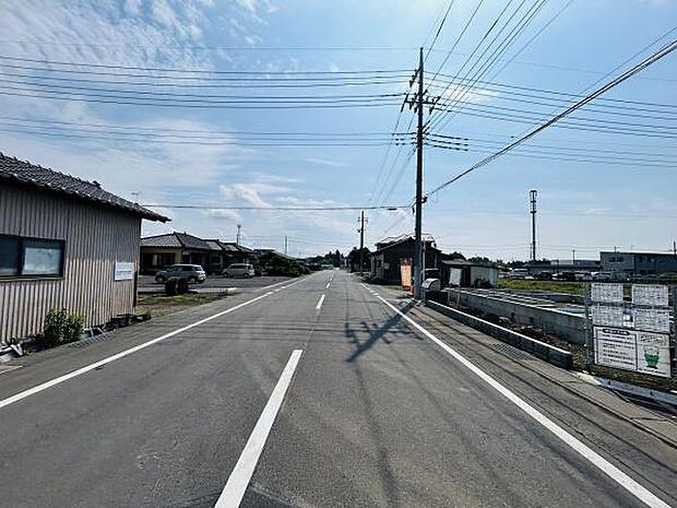 前面道路は広々とした道幅が確保されており見通しが良い環境です。周辺には住宅や畑が点在し静かな雰囲気が感じられます。電柱や標識などの設備が整っていますので安心してご利用いただけます。