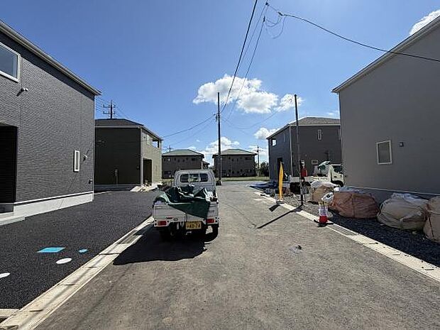 前面道路は幅員が広く車の出し入れがしやすい環境です。現地は日当たりもしっかりと確保されています。周囲には新しい建物が立ち並び整った街並みが特徴です。道路沿いのスペースもゆとりがあり開放感があります。