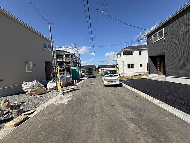 前面道路は広さがあり車の通行や駐車がしやすい環境です。周辺は新しい建物が建ち並び清潔感が感じられます。現地は日当たりも良く明るい雰囲気です。道路の舗装も新しく生活のしやすさが伝わります。