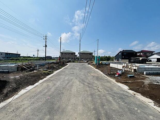 新しく整備された前面道路に面した現地の様子です。周囲は開放感のある環境で幅の広い道路が特徴的です。電線や住宅も整然と配置されており住環境が整っています。新築分譲地ならではの清潔感が感じられます。