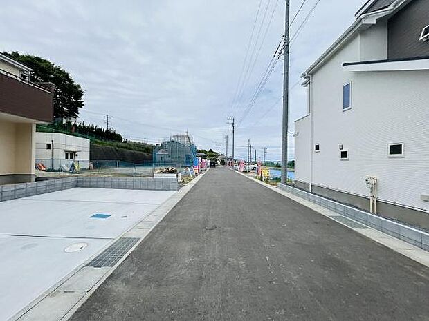 前面道路が広々としており車の出し入れがしやすい環境です。周囲は新しい建物が並び開放感があります。道路沿いには電柱も整然と設置されておりすっきりとした印象です。道路の舗装もきれいに整えられています。