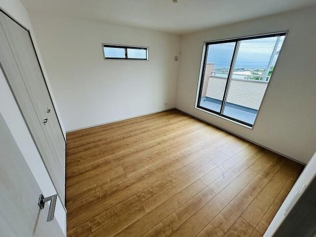 大きな窓から自然光が差し込む明るい寝室です。シンプルな内装で使い勝手の良い空間となっています。収納スペースもしっかり確保されています。落ち着いた雰囲気が広がるフローリング仕様です。