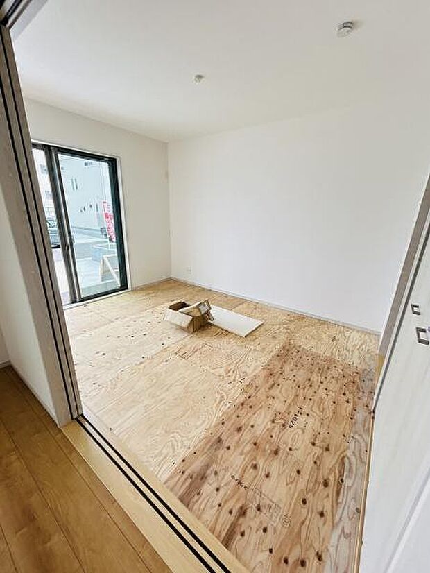 大きな窓から自然光がしっかり入る明るい和室です。シンプルな内装が印象的な空間です。スライドドアで開放感を感じられます。壁や天井も白で統一され清潔感があります。使い方次第でさまざまな用途に対応可能です。